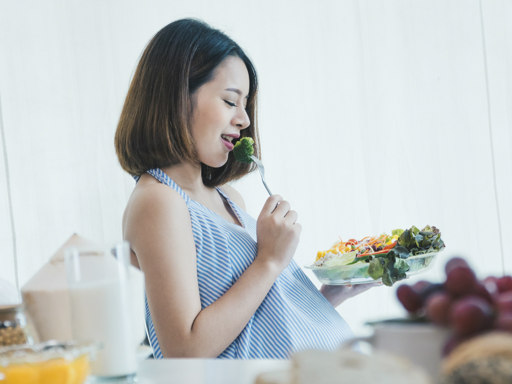 pregnant woman eating broccoli