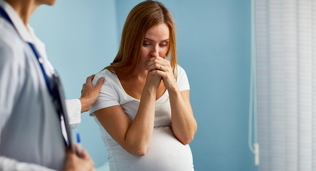 embarazada llorando en consulta del doctor