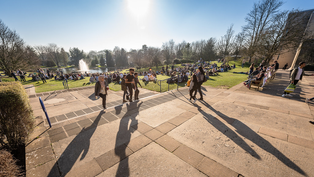 Students walking beside the lake on campus.