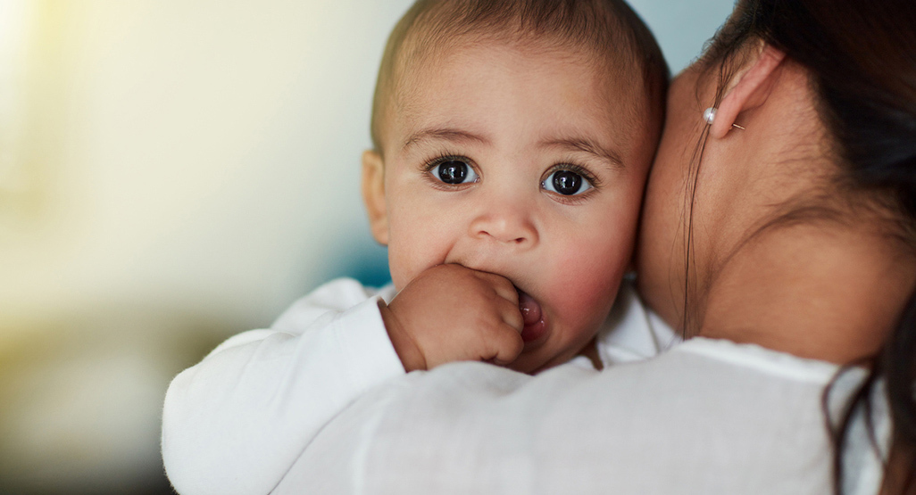 Bebê com dentinho nascendo morde a mão