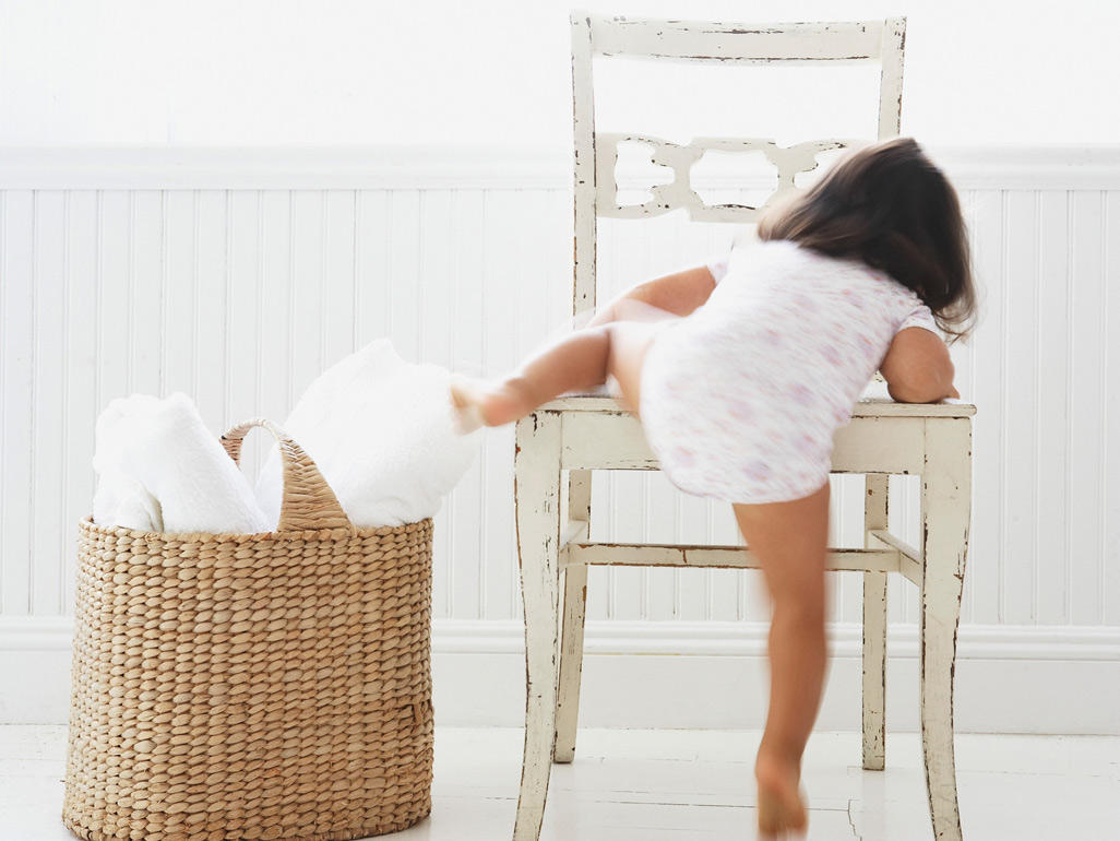 Toddler climbing up onto a chair