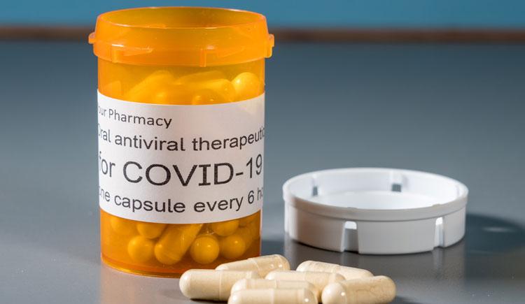 Image of a pill bottle that says COVID Rx with some pills near it