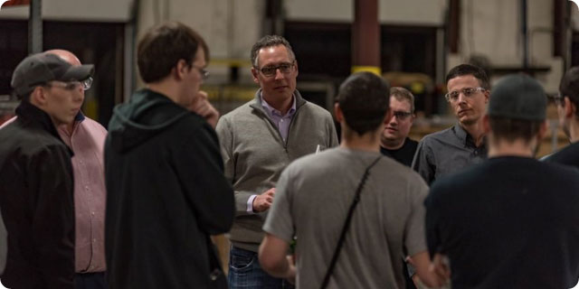 Ownership Works is the brainchild of Pete Stavros, co-head of private equity for the Americas at KKR, shown in a gray sweater with CHI Overhead Doors workers in 2018.