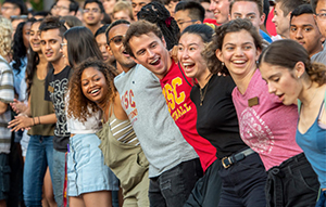 A line of USC students with arms interlocked participating in a welcome week event on campus.