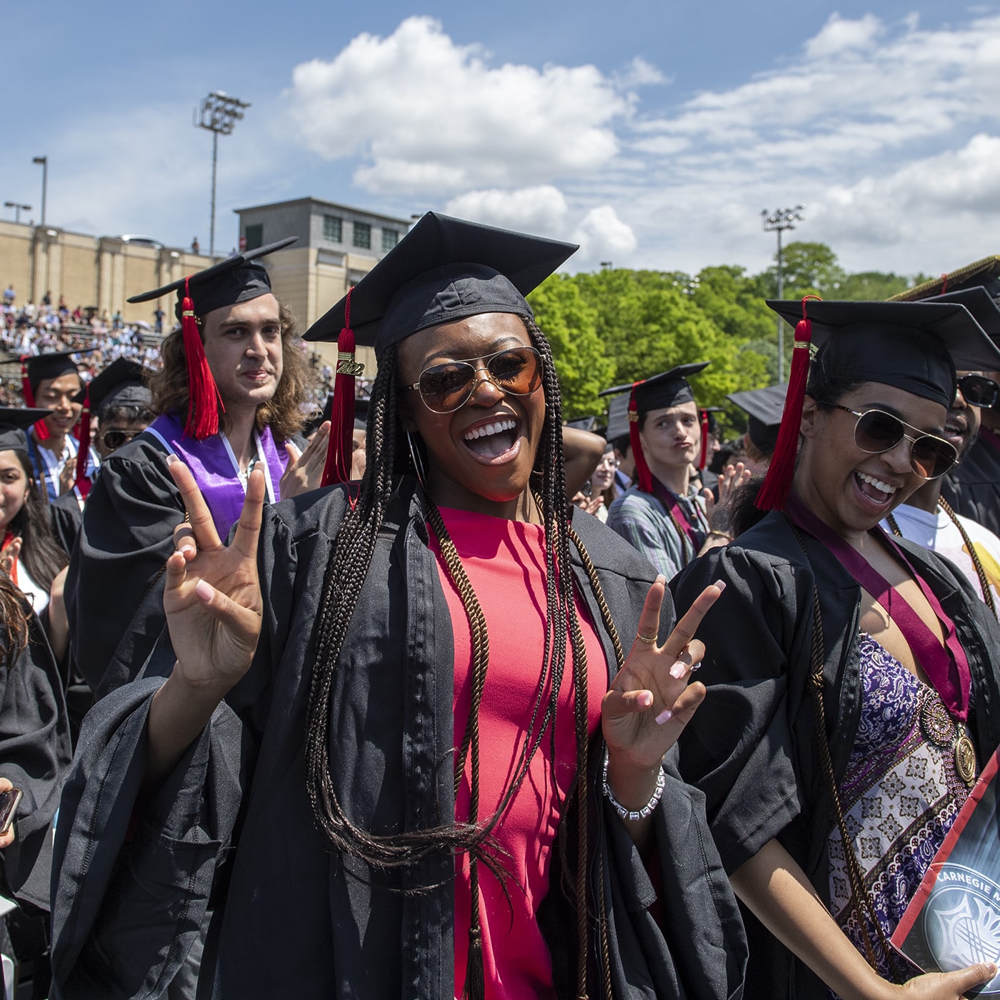 Students cheering in caps and gowns