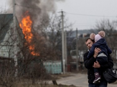 Residents flee from the town of Irpin, Ukraine, after heavy shelling by Russia destroyed the only escape route used by locals, March 6, 2022, photo by Carlos Barria/Reuters