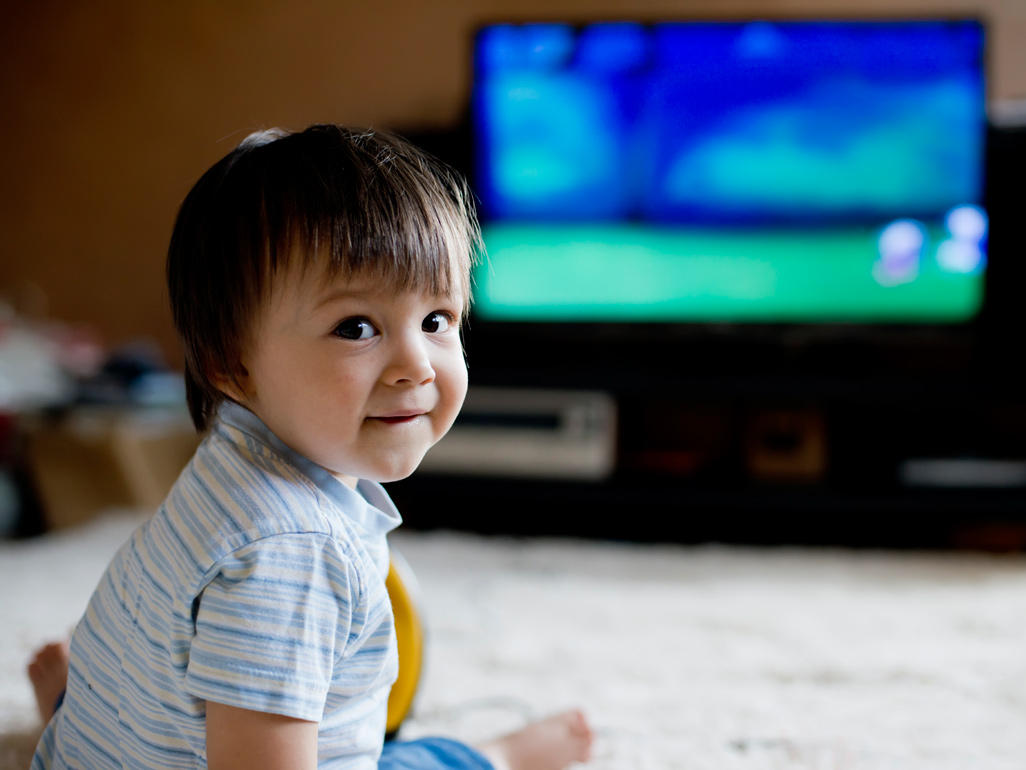 toddler siting on the flood and watching tv