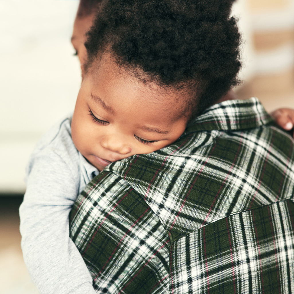 infant sleeping in mother's arms