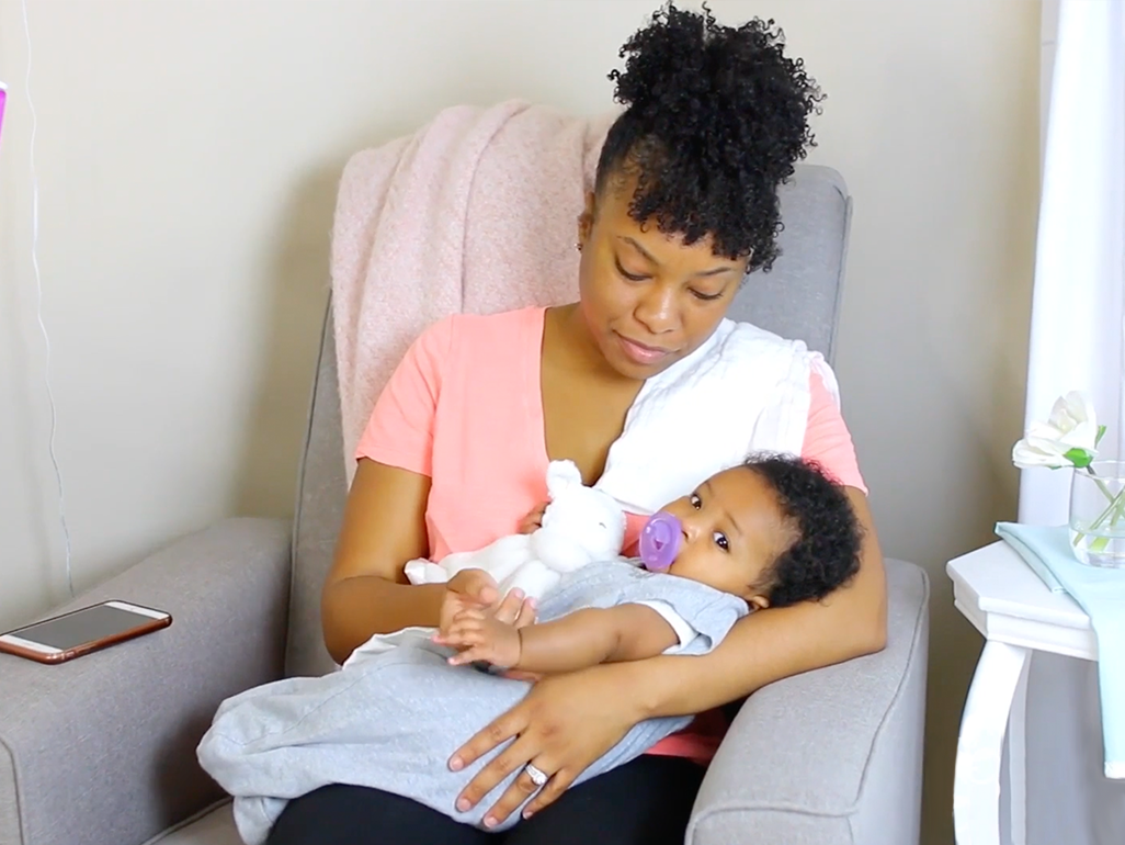 mom in chair holding baby, with phone on chair's arm