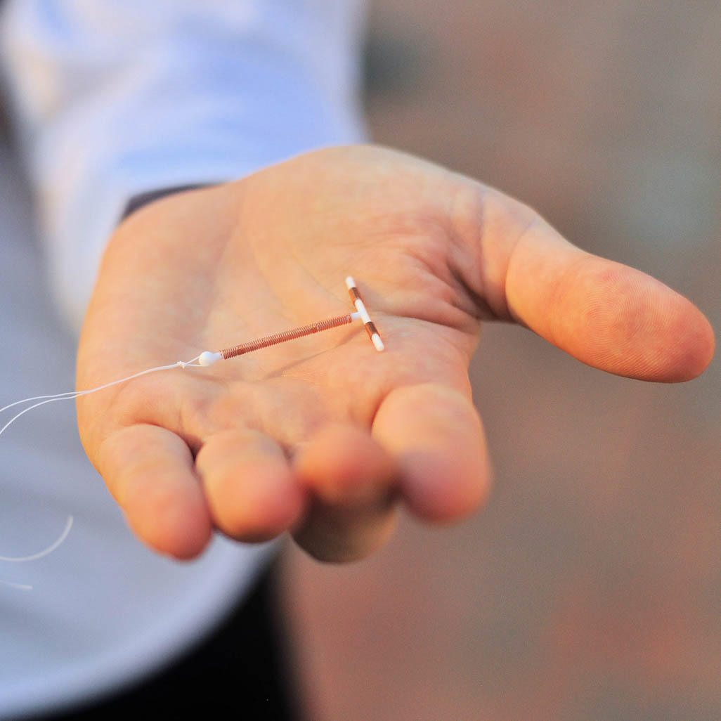 woman holding an IUD in hand