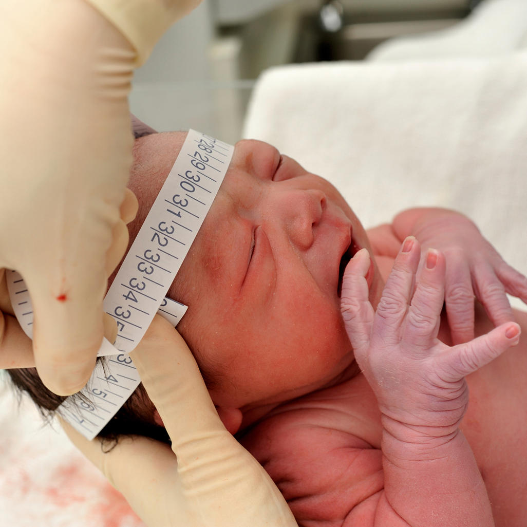 newborn having head measured at hospital