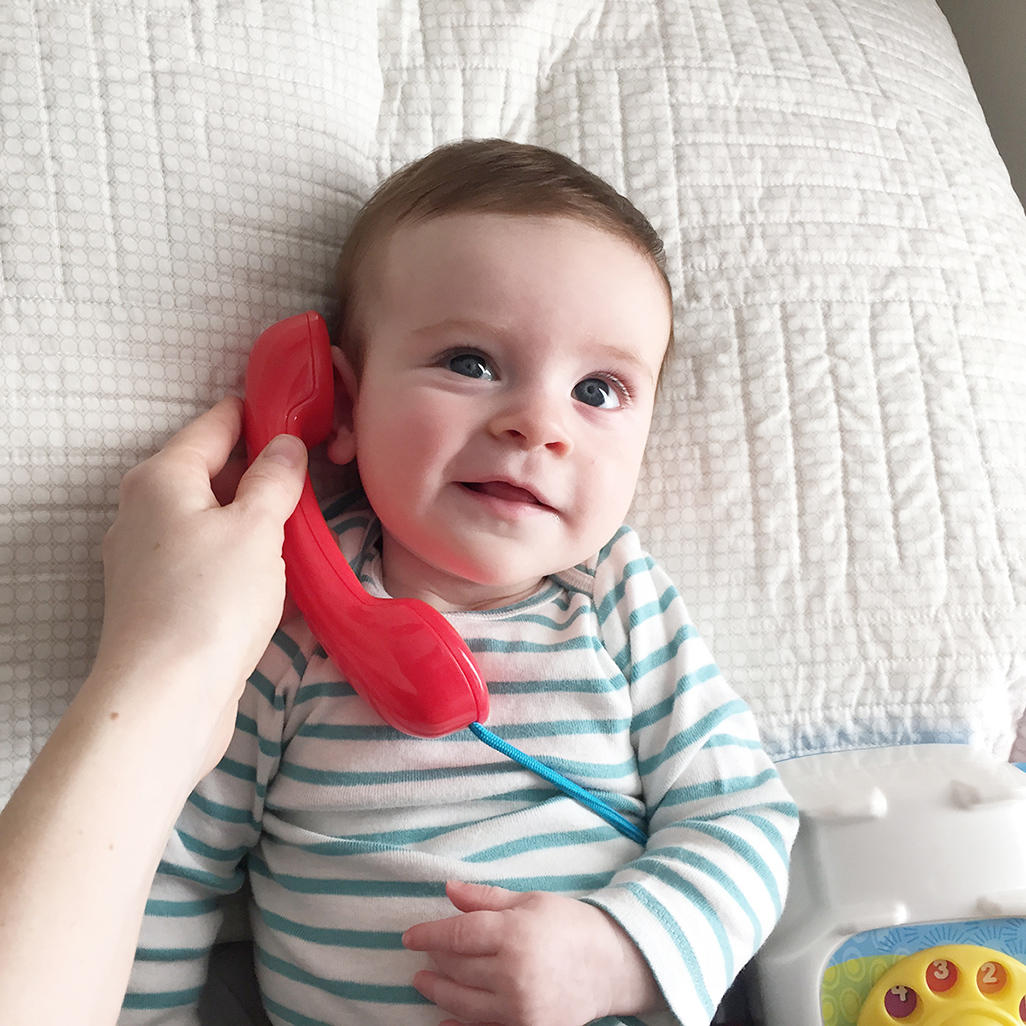 baby talking on toy telephone