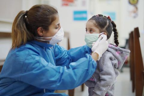 Una enfermedad toma la temperatura de una niña en el Líbano