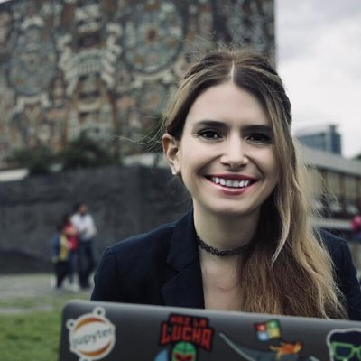 Saiph Savage. Assistant Professor, Department of Computer Science and Electrical Engineering, West Virginia University. Wearing a black jacket and necklace, and holding a laptop with stickers.