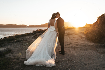 Just married couple kissing near the ocean