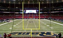 Photograph of a football field taken from the end zone showing goal posts in the foreground