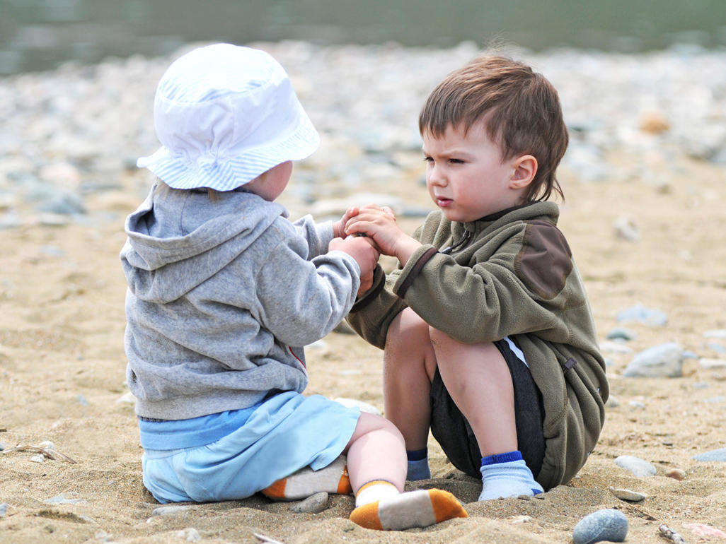 طفلان يتشاكسان على الشاطئ