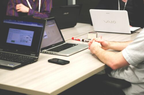 Working On Laptops Around Desk Free Stock Picture