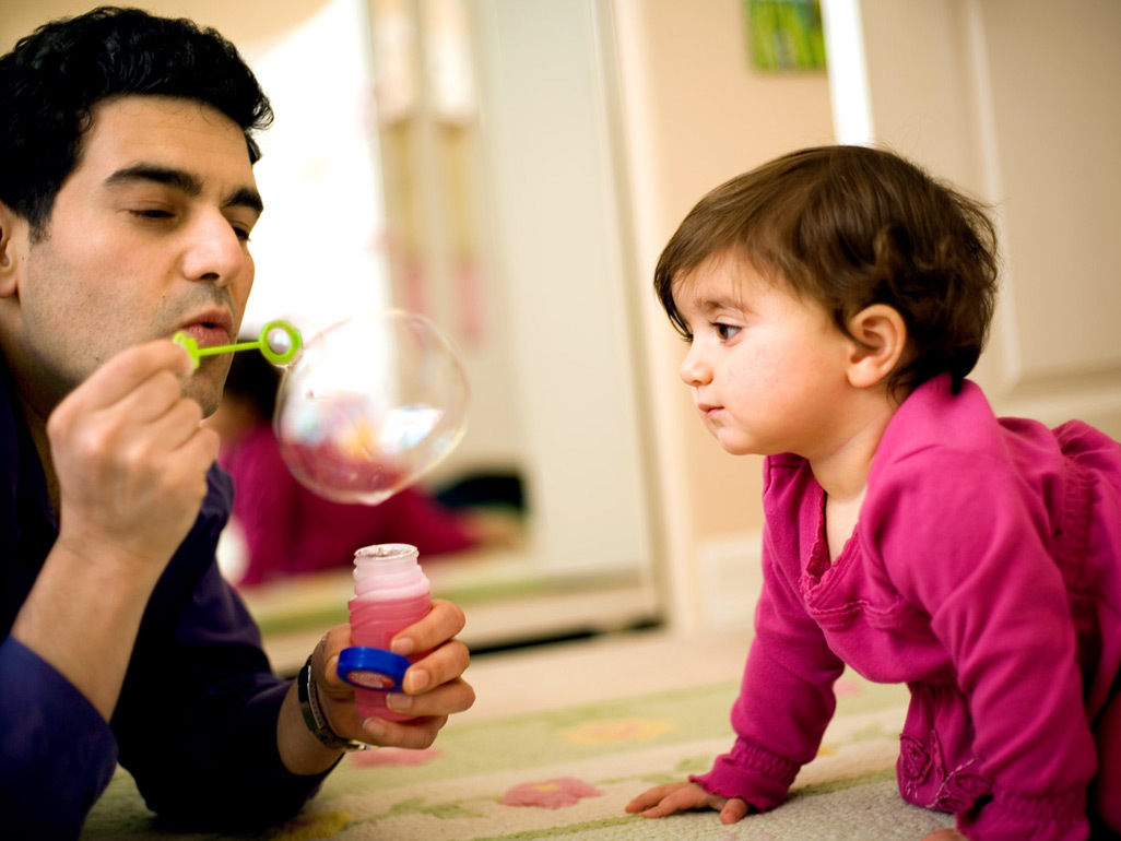 Dad blowing bubbles for baby