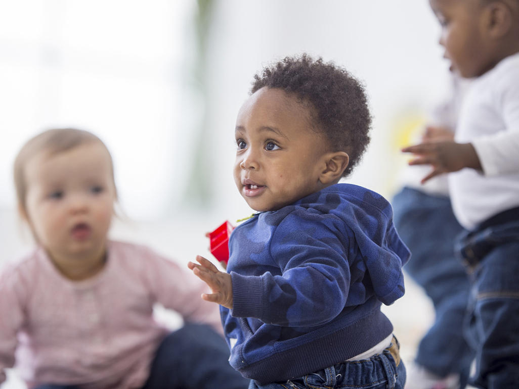 four babies playing alongside each other