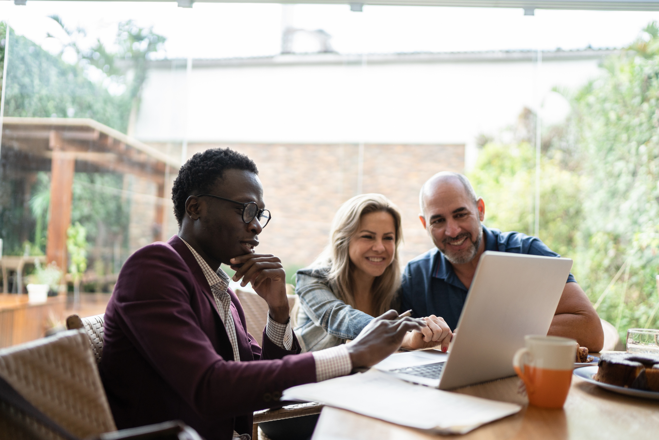 Real estate agent or finance advisor doing a meeting with couple at home