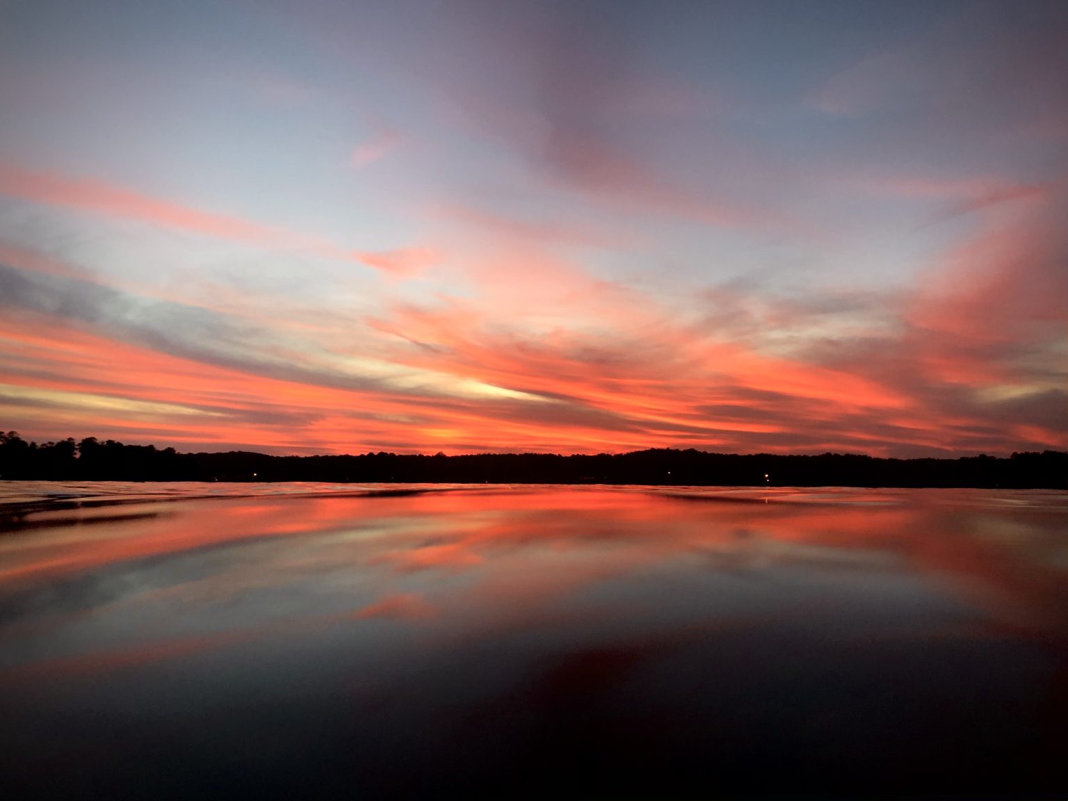 Colorful sunset on Lake Harding in Alabama (USA) with red and blue color tone. Colors and clouds are reflected in the water.