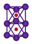 The ball-and-stick diagram shows two regular octahedra which are connected to each other by one face. All nine vertices of the structure are purple spheres representing rubidium, and at the centre of each octahedron is a small red sphere representing oxygen.