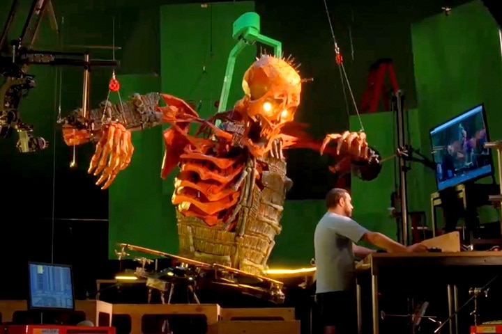 An animator uses a computer to control the movements of a giant skeleton puppet. Image courtesy of LAIKA.