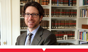 Faculty member smiling in front of bookcase