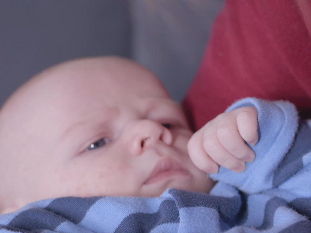 baby in warm pajamas being held