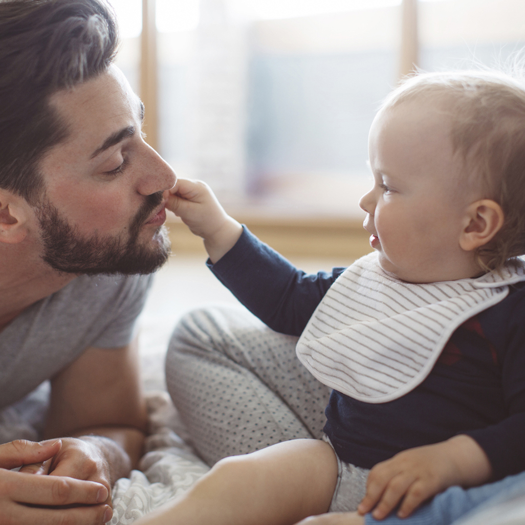 baby reaching over and touching dad's lips