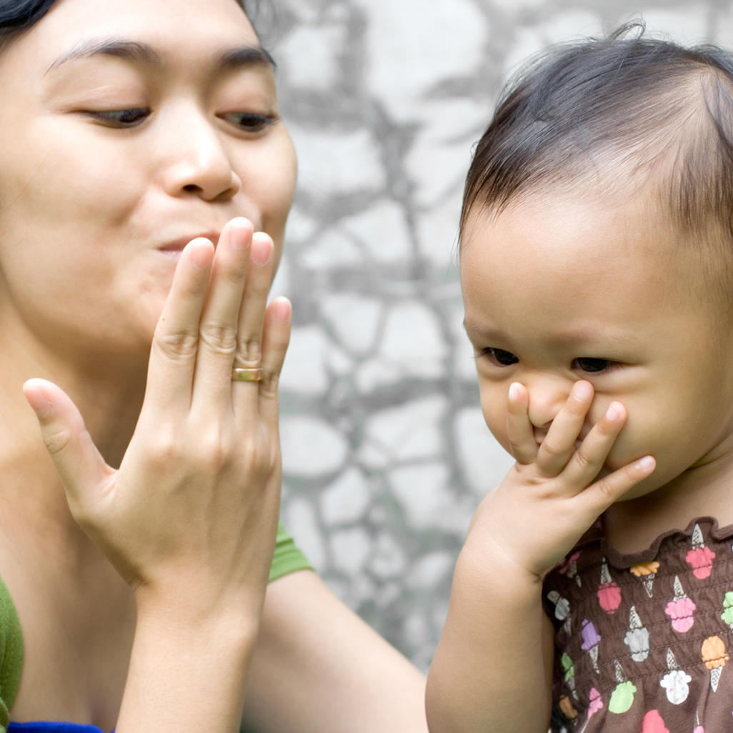 mom and girl kissing their palms