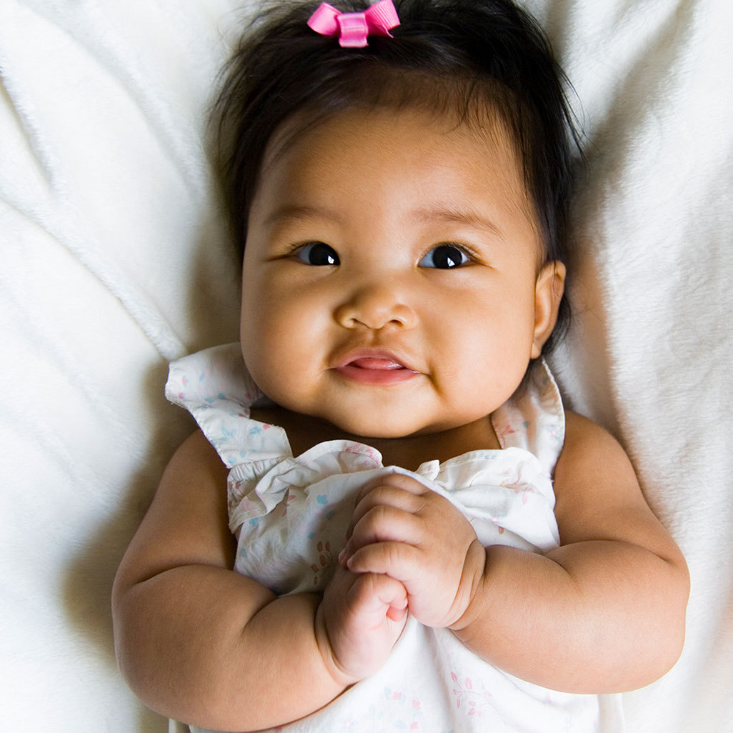 baby girl lying on her back smiling