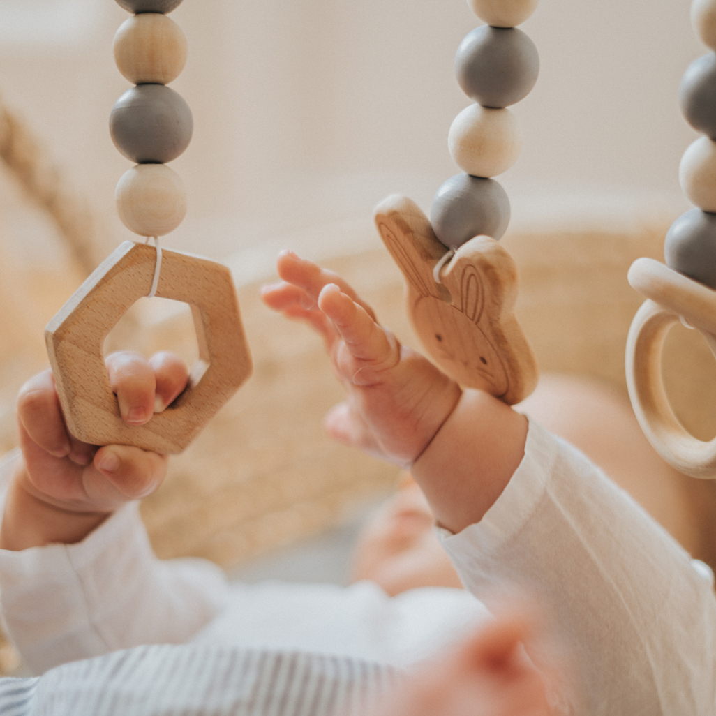 baby reaching and grabbing dangling toys