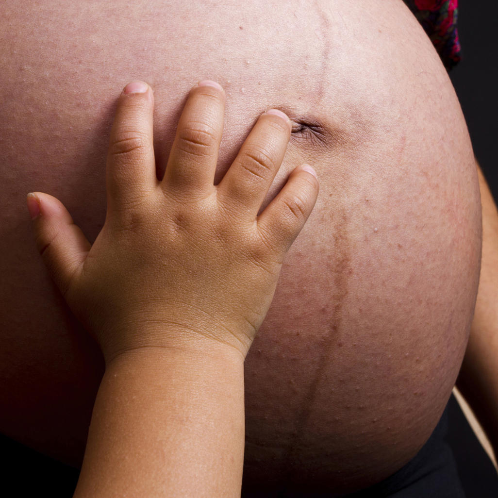 baby's hand on a pregnant woman's belly