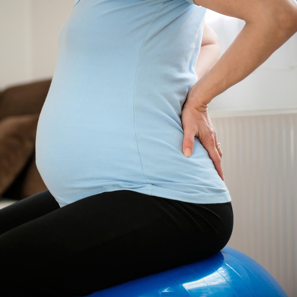 pregnant woman pushing on her own back