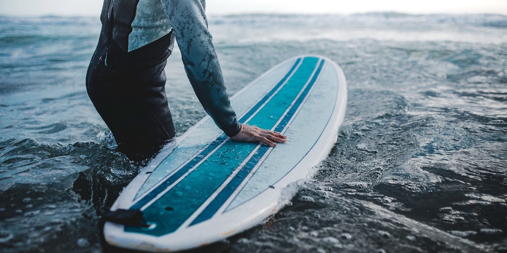 Male surfer headed out to catch waves