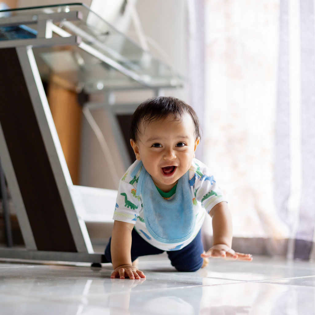 smiling little boy crawling on the floor