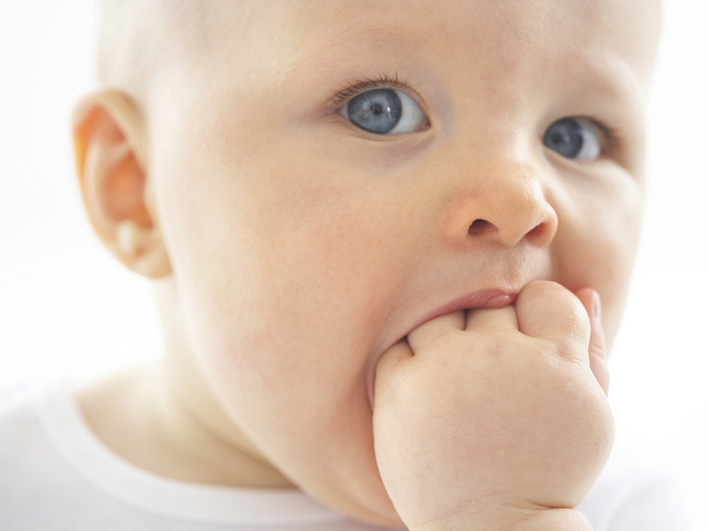 baby putting fingers in mouth