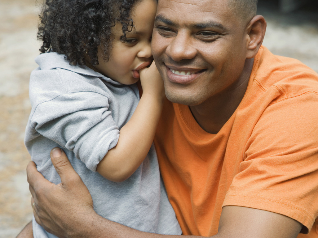 boy sucking thumb hugging his father