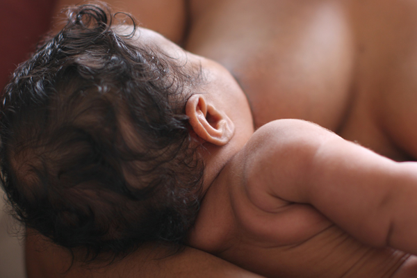 Close-up photo of a baby breastfeeding.