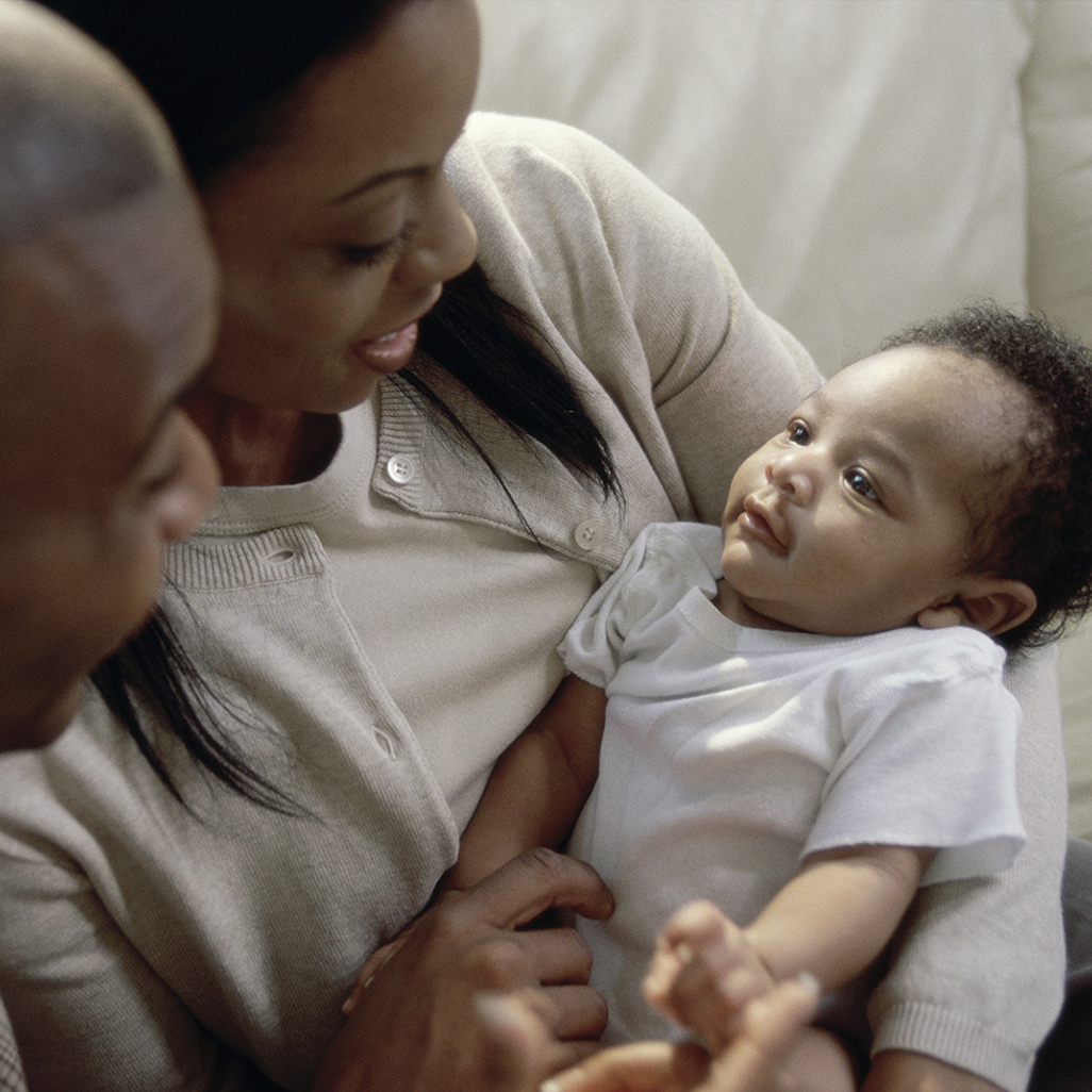 woman holding baby on couch