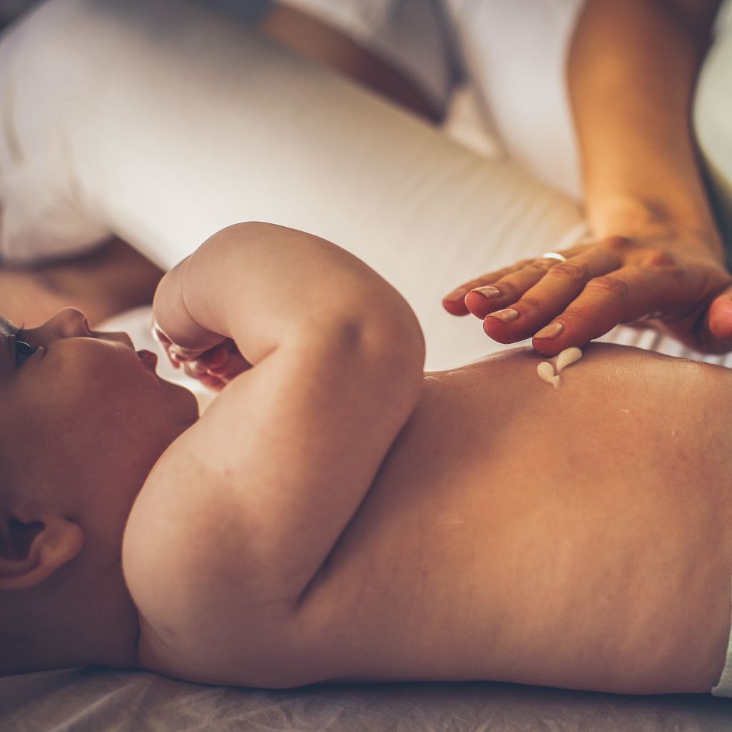 applying lotion on baby's cheek