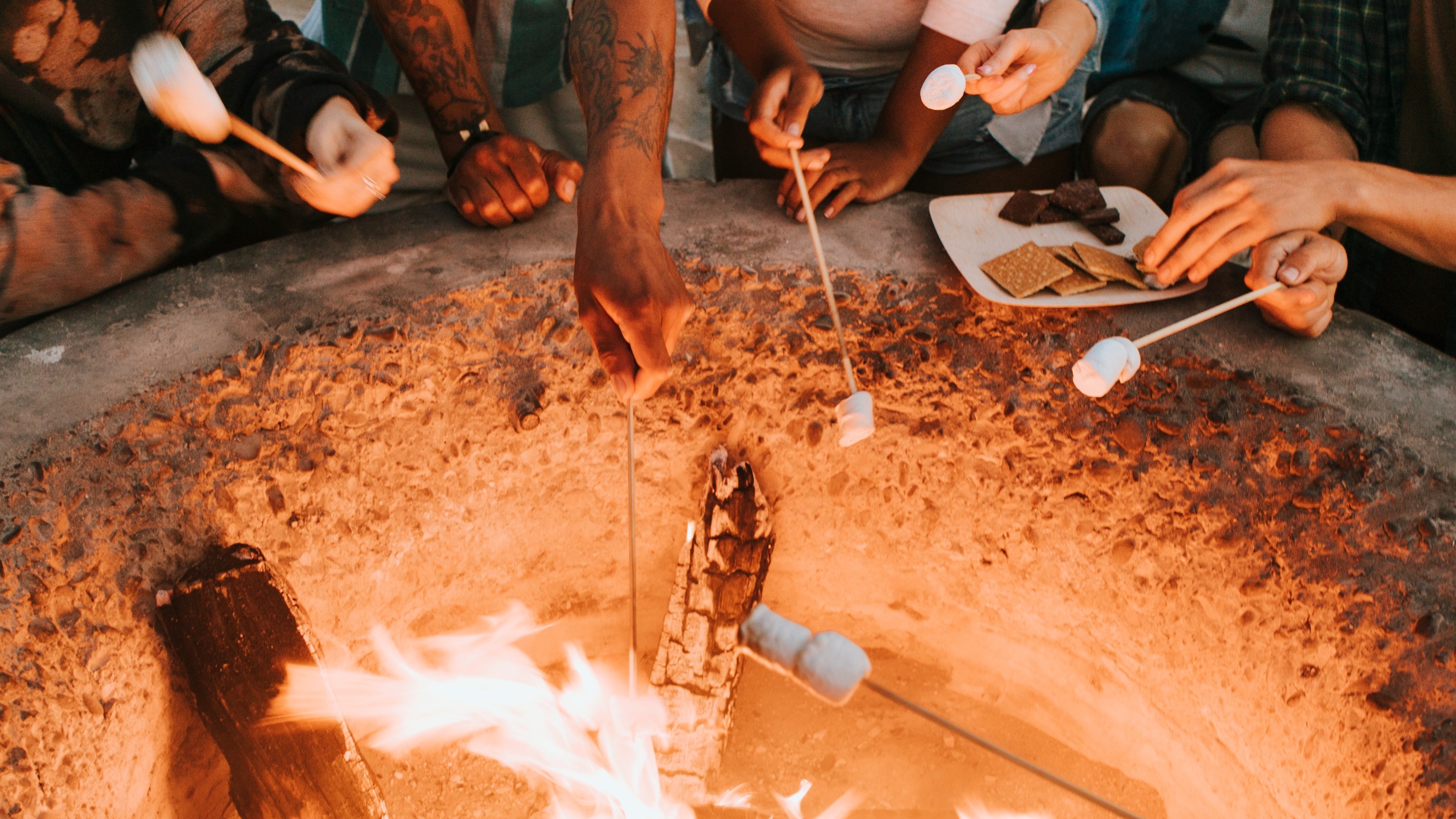 Friends roasting marshmallows on the beach