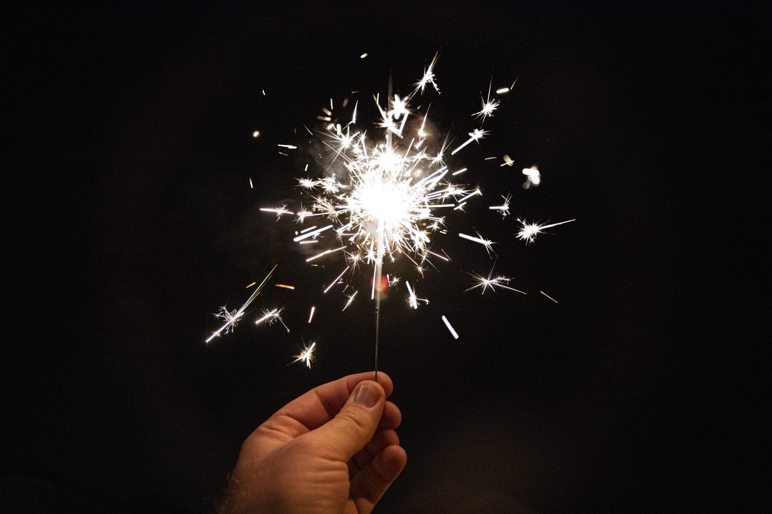 A hand holding a sparkler firework at night. Photo contributed by Marcus Burnette to the WordPress Photo Directory.