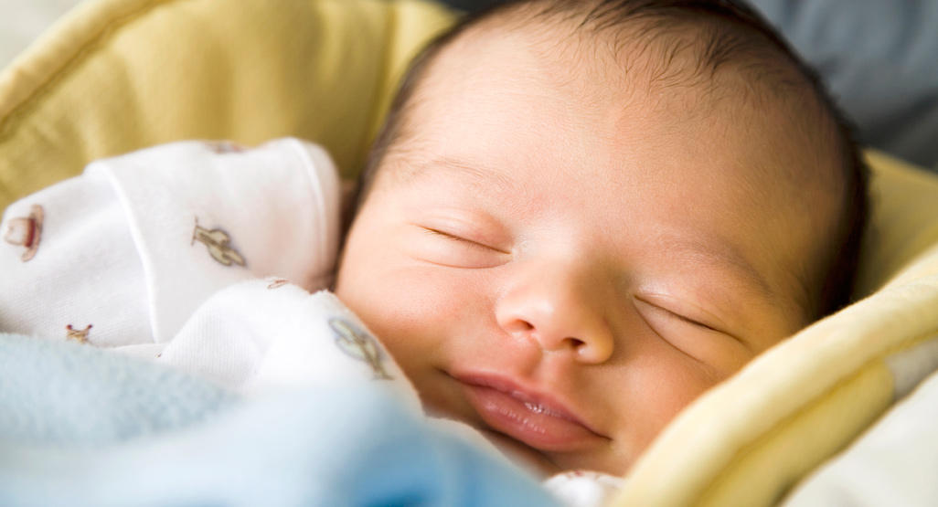 Happy, smiling baby in a seat