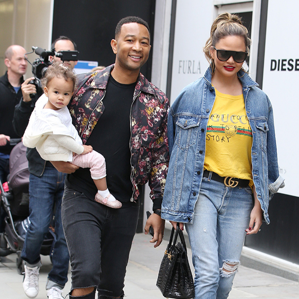 john legend and chrissy teigen walking outdoors with baby