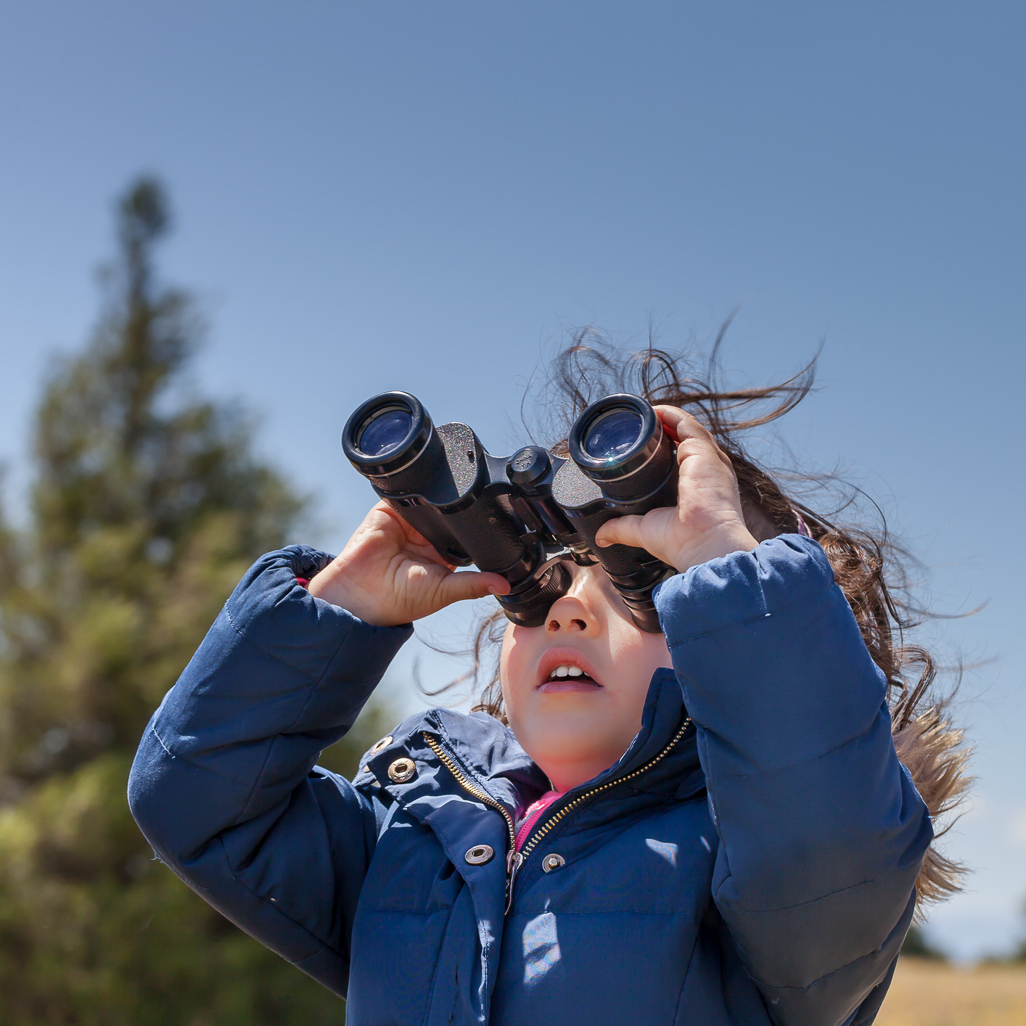 little girl looking thru binoculars