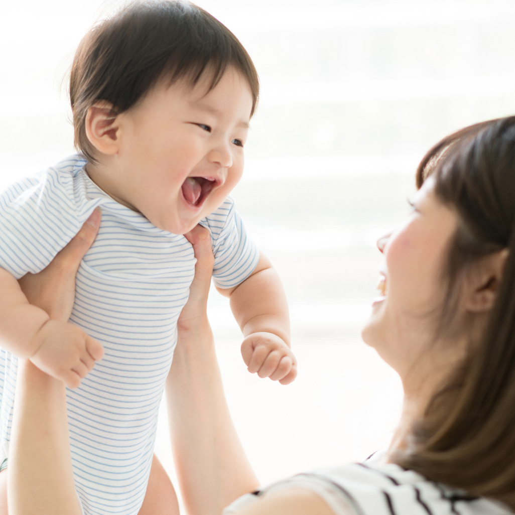 Smiling baby held by mom