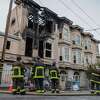 Firefighters observe the aftermath of a structure fire on McAllister Street in San Francisco, Calif., on Tuesday, Aug. 23, 2022. The three-alarm fire injured one woman.